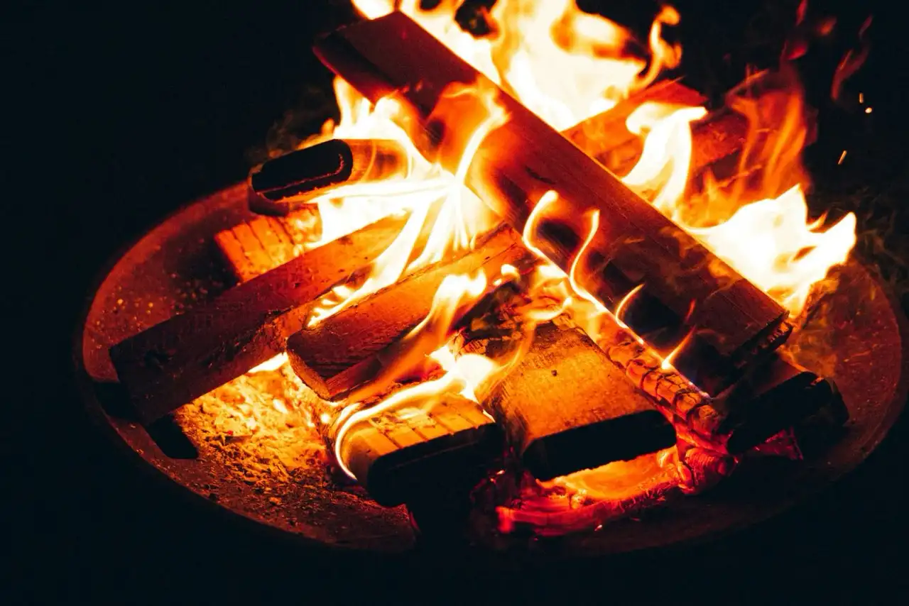 Campfire burning in a round fire pit at night, Chemainus BC