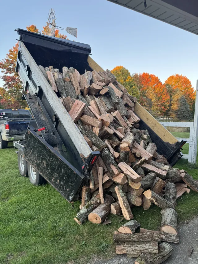 Dump trailer tipping a load of split firewood, Duncan BC