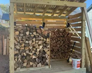 Firewood in Oak Bay BC: split firewood stacked in a backyard woodshed