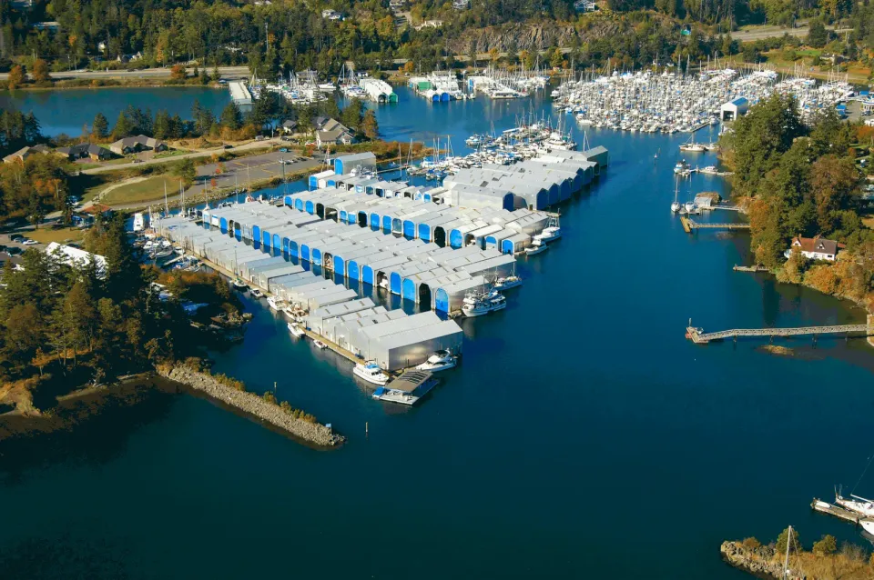 Aerial view of a marina with covered boathouses and sailboats, North Saanich BC