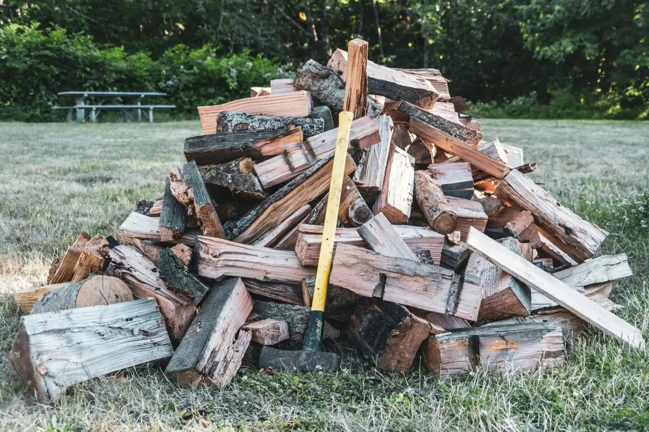 Pile of split firewood with a sledgehammer on a lawn, Duncan BC